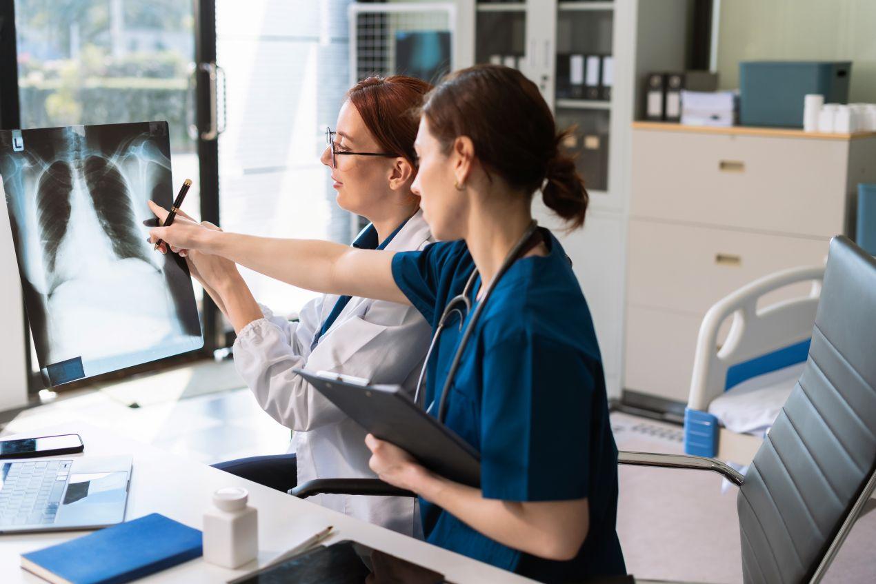 Radiologie Frankfurt: Zwei AErztinnen analysieren Roentgenbilder gemeinsam in einem radiologischen Untersuchungsraum