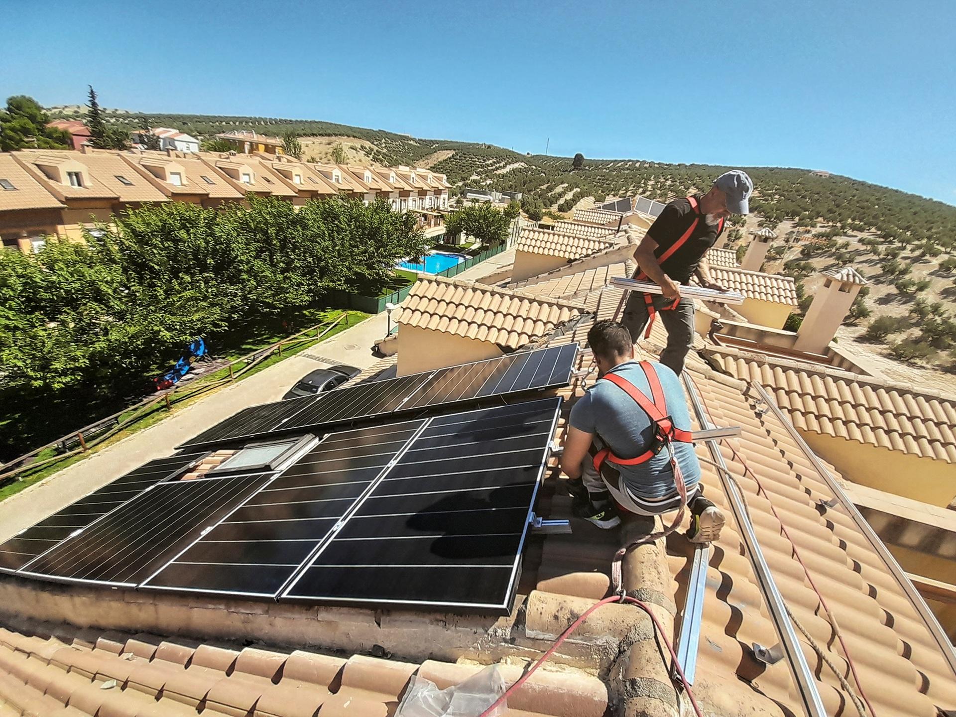 Zwei Monteure installieren Solarpanels auf Dach | Arbeitsbühne mieten

