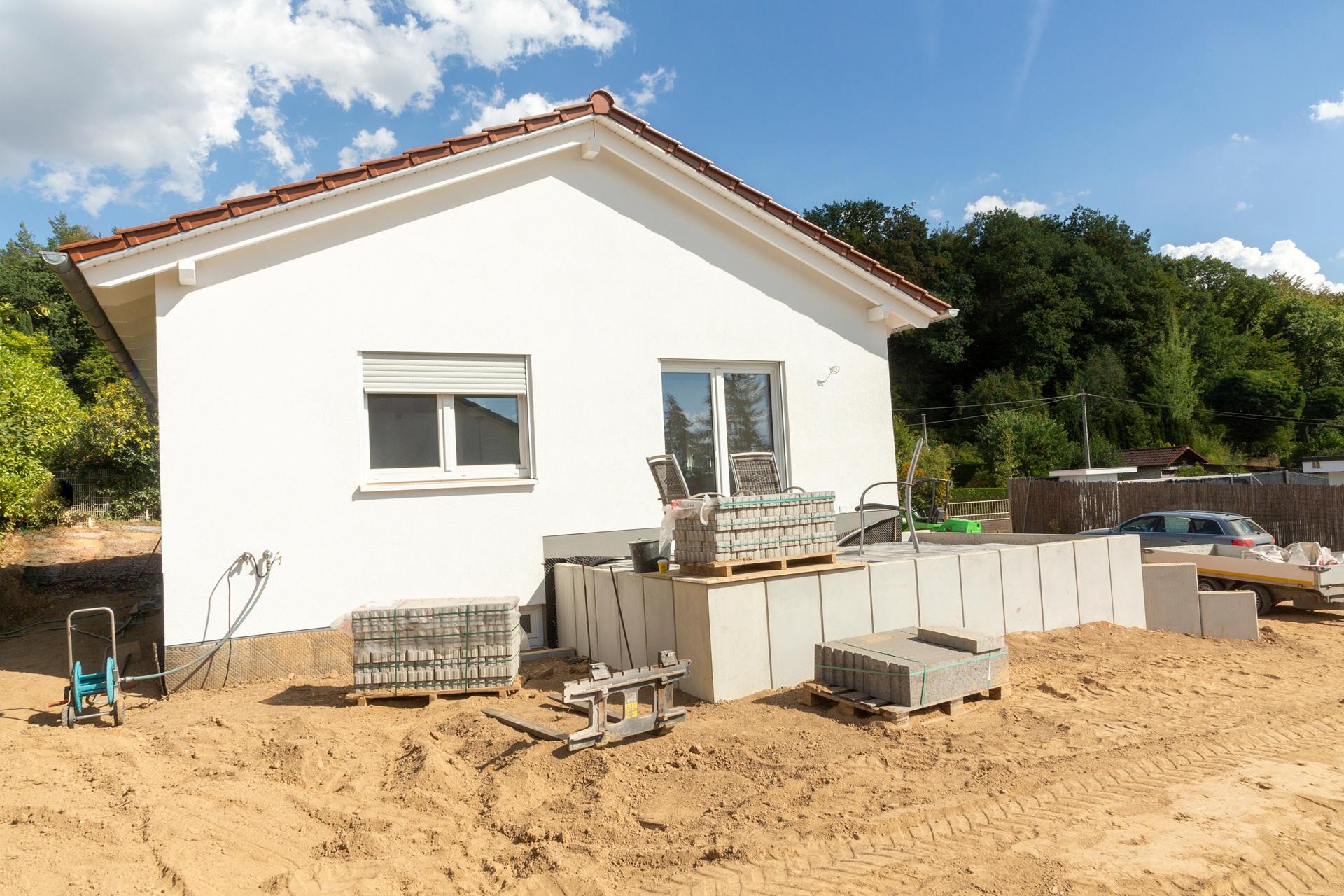 Baustelle vor Haus mit Material und Werkzeug | Arbeitsbühne mieten

